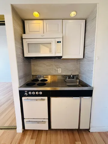 a kitchen with a stove and a white cabinet