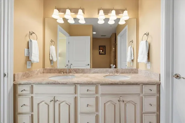 a bathroom with a granite countertop sink and a mirror