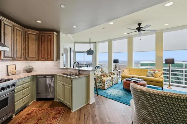 a kitchen with stainless steel appliances granite countertop sink stove and wooden cabinets