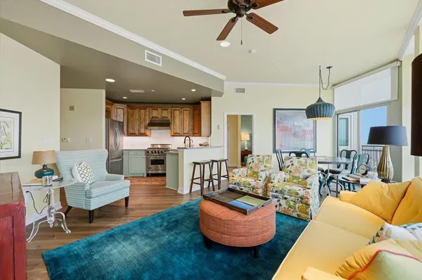 a living room with furniture kitchen view and a chandelier