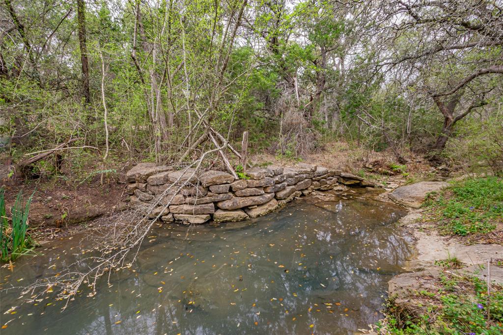 250 Mail Rte Road Fischer, TX 78623 - Photo 5 of 29 Creek and old well. This 1,950-square-foot home includes its own water well, septic system, tankless hot water heater, wood-burning stove as heat source, and window air conditioning. The property also features a barn. While the home requires updates and repairs, it is conveniently located at the front of the property with a gated entrance.