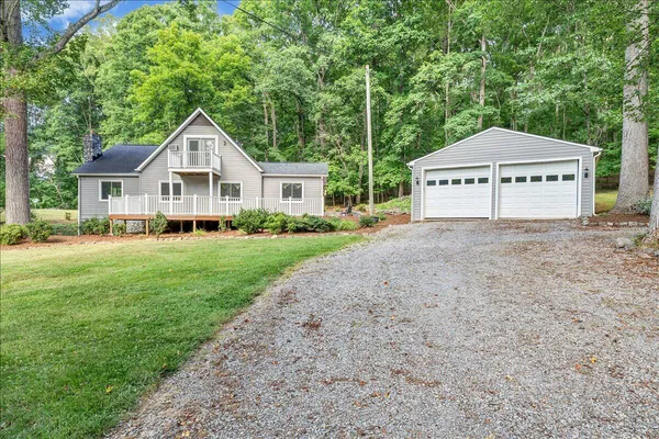 a view of a house with a yard and large trees