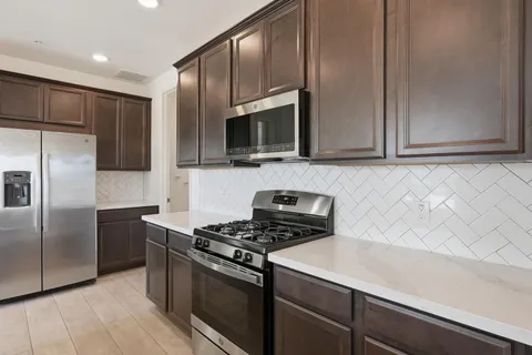 a kitchen with a sink a microwave a stove and refrigerator