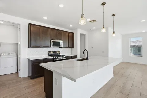 a view of kitchen with kitchen island and stainless steel appliances