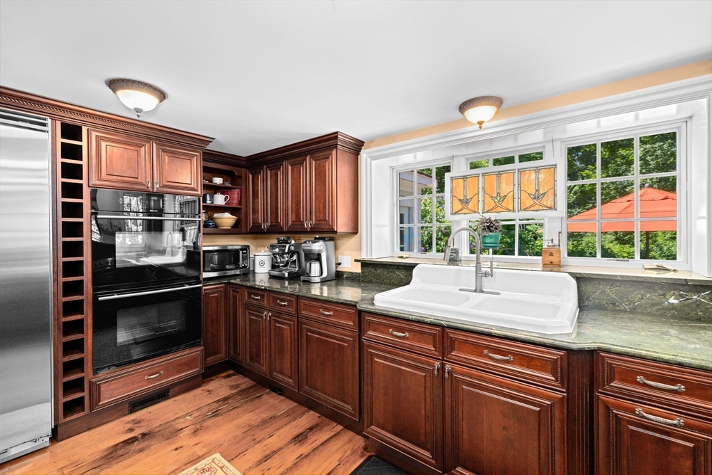 71 High Street Canton, MA 02021 - Photo 8 of 42 a kitchen with kitchen island granite countertop a stove a sink and cabinets