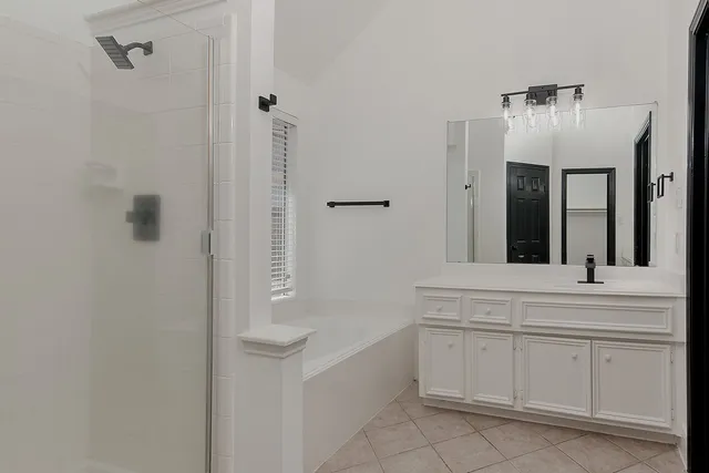 a spacious bathroom with a bathtub sink and mirror