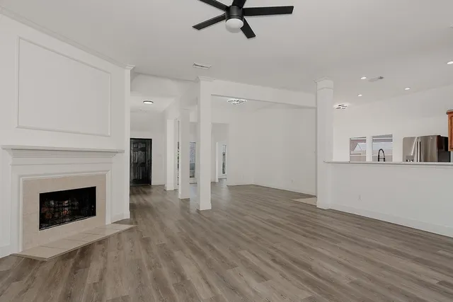 a view of a livingroom with wooden floor and a fireplace