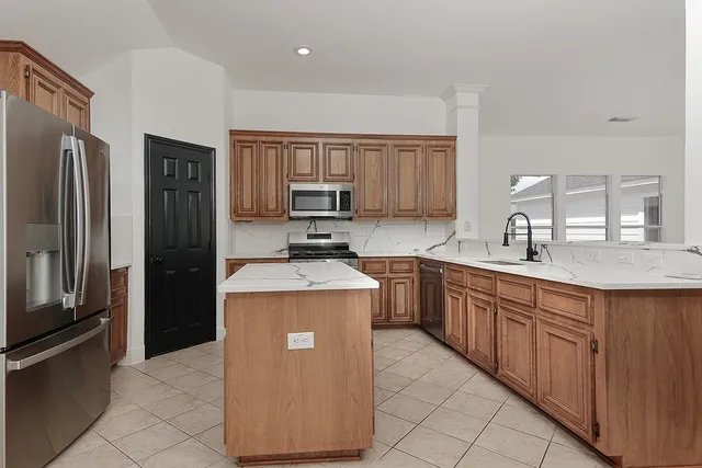 a kitchen with stainless steel appliances granite countertop a refrigerator stove and sink