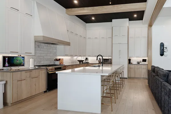 a kitchen with stainless steel appliances granite countertop a sink a stove and a refrigerator
