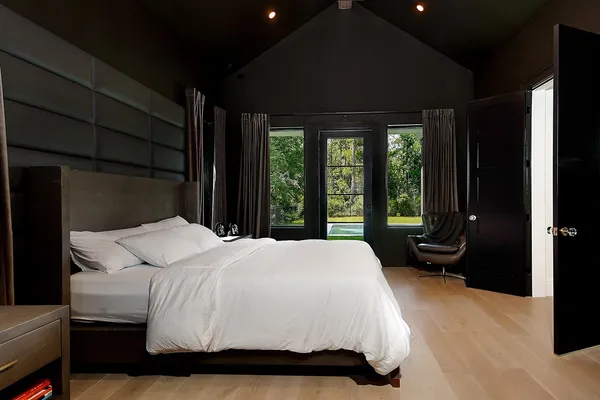 a bedroom with a bed lamp closet and large window