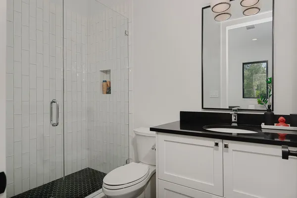 a bathroom with a granite countertop sink and a mirror