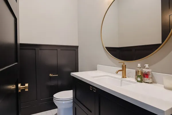 a bathroom with a sink mirror and toilet