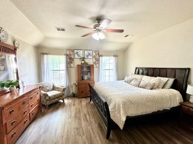 a bedroom with a bed and wooden floor