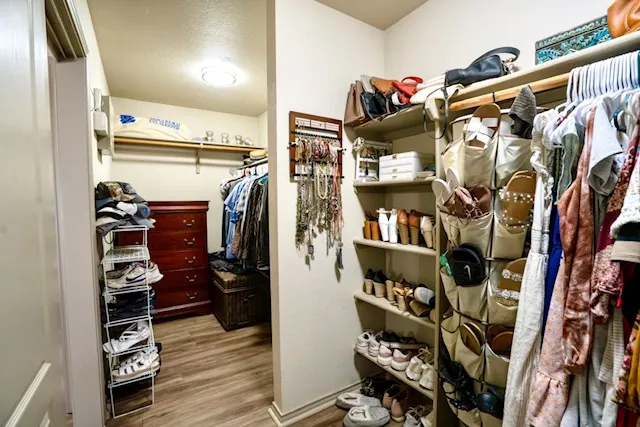a view of walk in closet with clothes and shoes