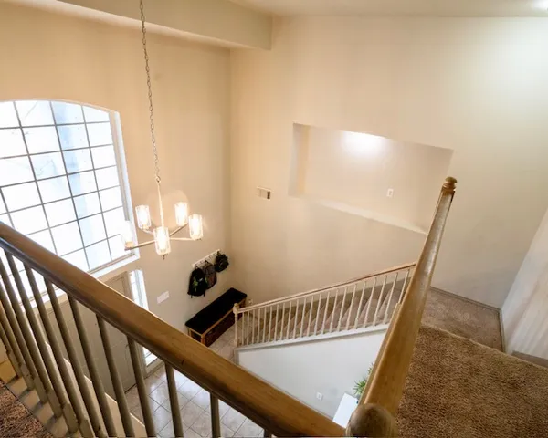 a view of staircase with railing and white walls
