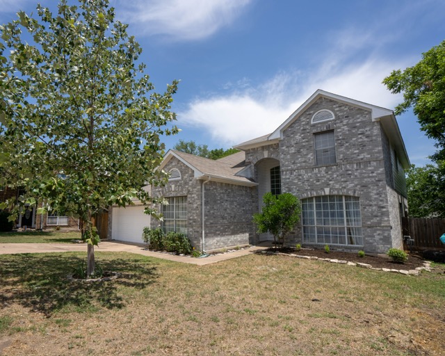 1406 Apache Cove Pflugerville, TX 78660 - Photo 3 of 40 a front view of a house with a yard