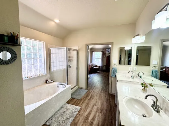 a spacious bathroom with a tub sink and mirror