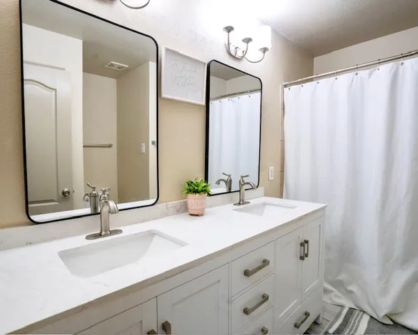 a bathroom with double vanity sink and a mirror