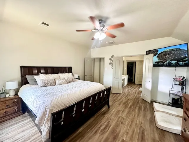 a bedroom with bed and wooden floor
