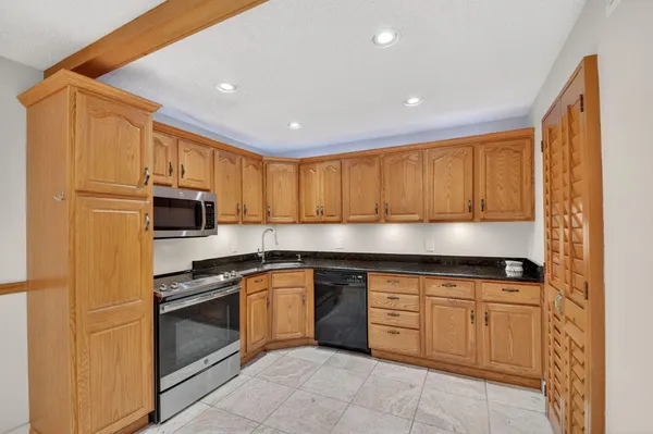 a kitchen with stainless steel appliances granite countertop a stove a sink and a microwave