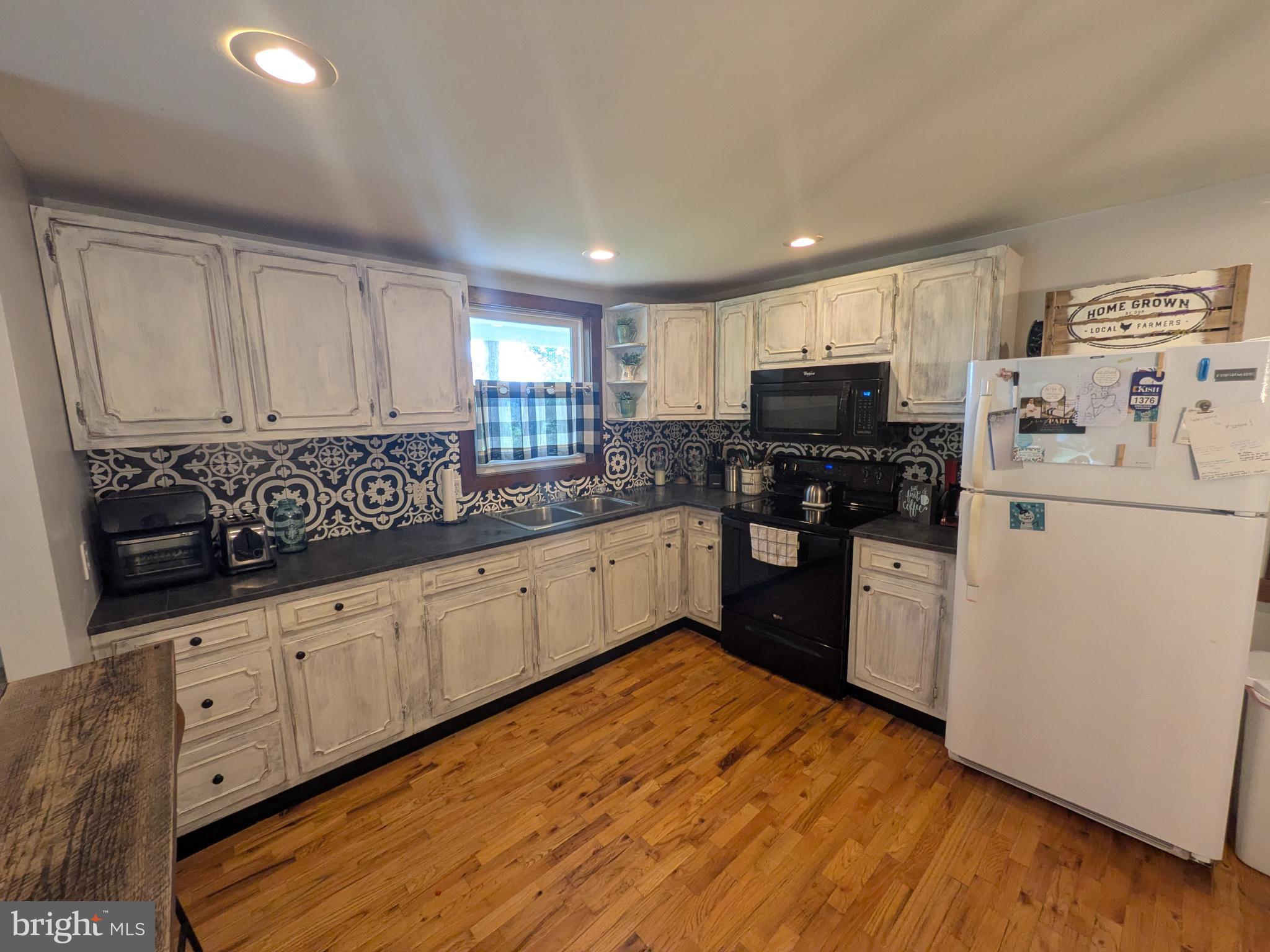 2418 Muddy Run Road Mifflintown, PA 17059 - Photo 20 of 44 a kitchen with granite countertop white cabinets and white appliances