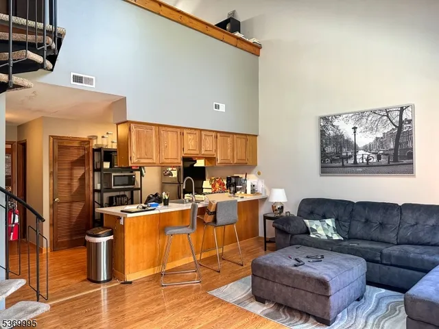 a living room with furniture kitchen view and a window