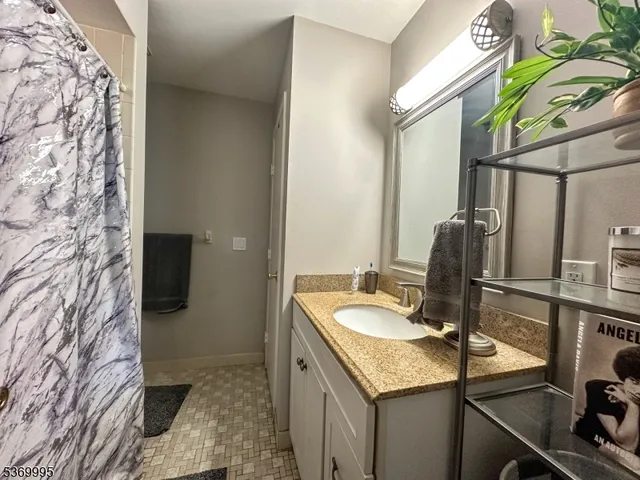a bathroom with a granite countertop sink a toilet and mirror