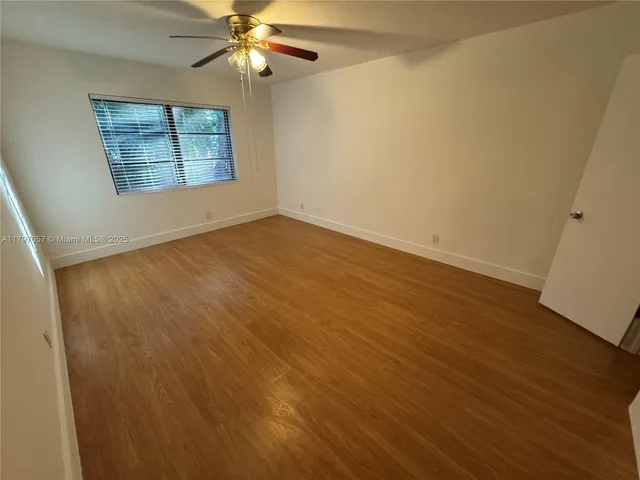 an empty room with a window and wooden floor