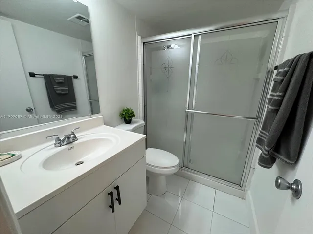 a bathroom with a sink a toilet a mirror and shower