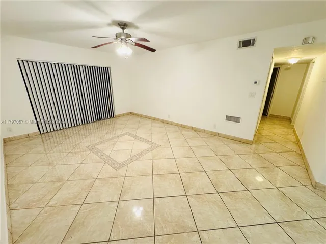 a view of a livingroom with wooden floor and a ceiling fan