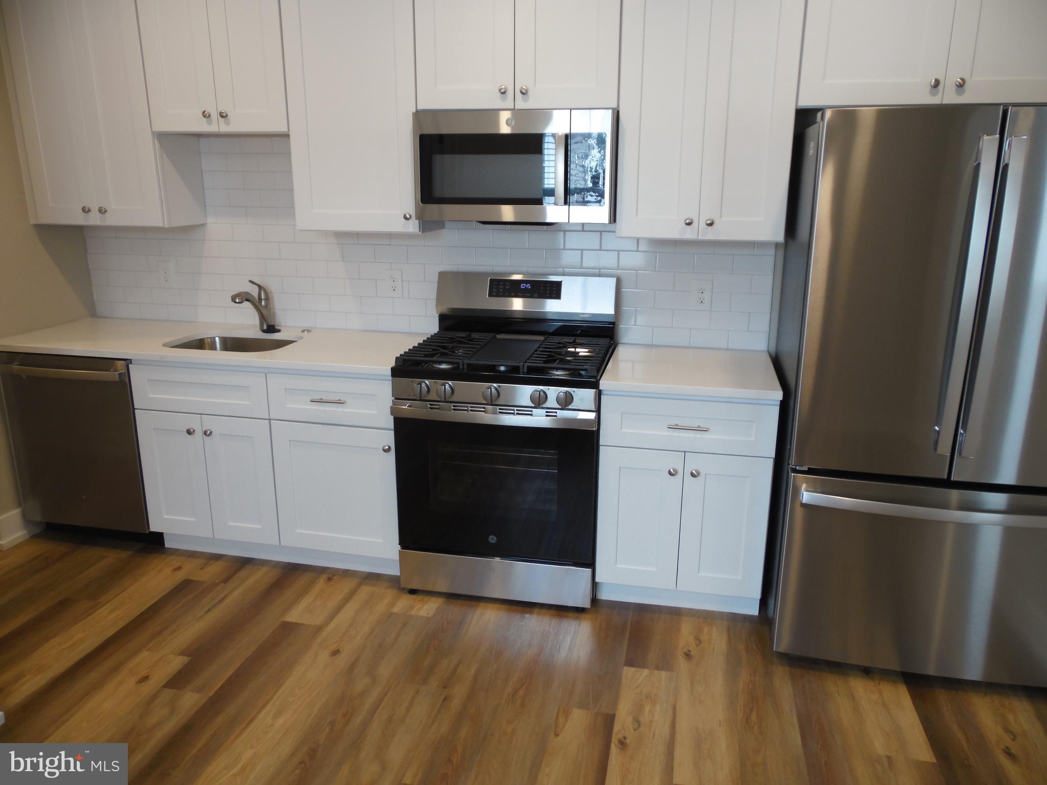 155 Channing Avenue, Unit 3 Malvern, PA 19355 - Photo 12 of 16 a kitchen with cabinets stainless steel appliances and wooden floor