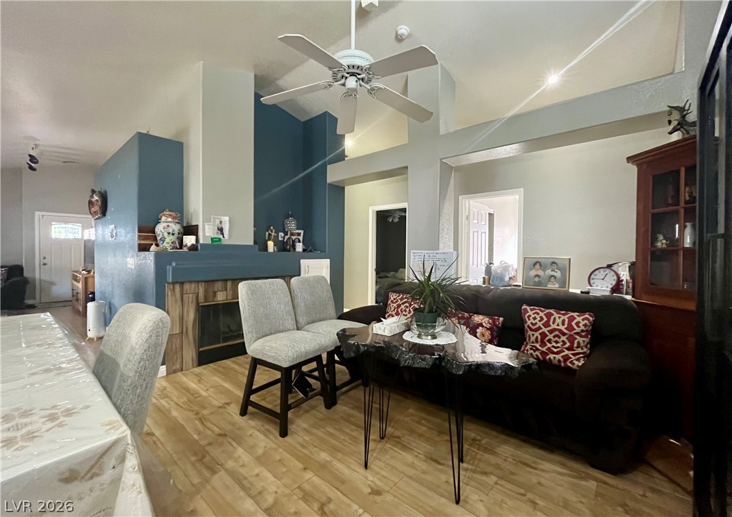 High ceilings and warm wood floors define this open living area highlighted by a fireplace.