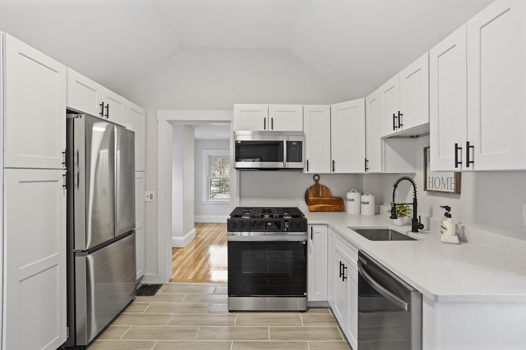 135 Cottage Street, Unit 2 Norwood, MA 02062 - Photo 5 of 30 a kitchen with granite countertop a refrigerator stove and sink
