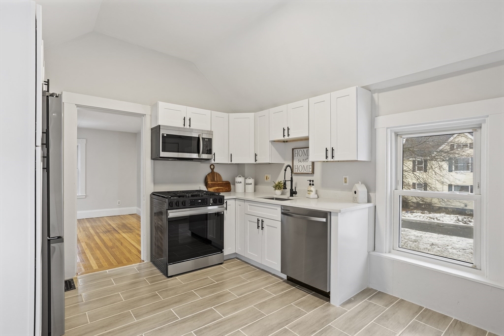 135 Cottage Street, Unit 2 Norwood, MA 02062 - Photo 7 of 30 a kitchen with a sink cabinets stainless steel appliances and a window