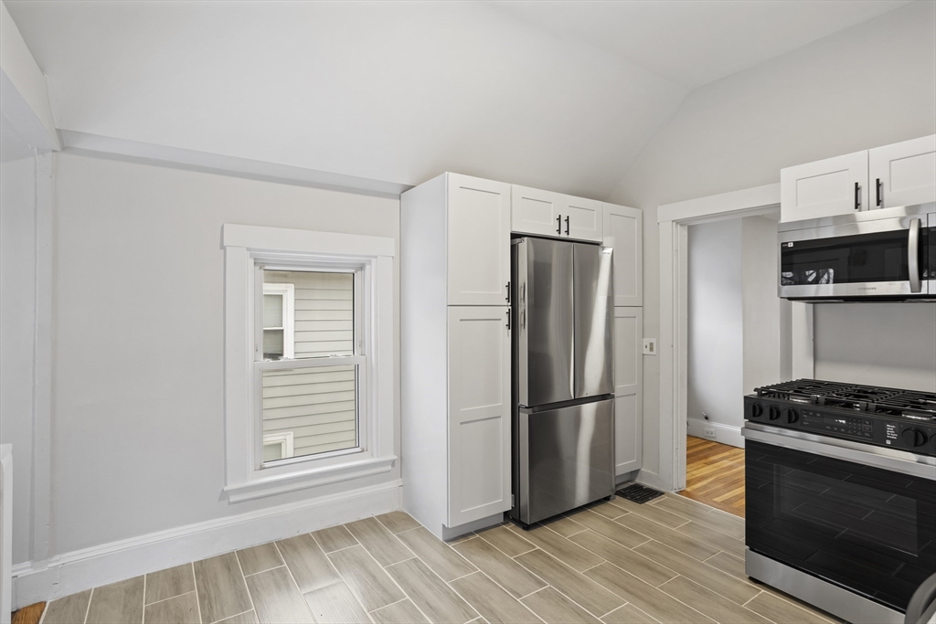 135 Cottage Street, Unit 2 Norwood, MA 02062 - Photo 8 of 30 a kitchen with granite countertop a refrigerator and a stove top oven