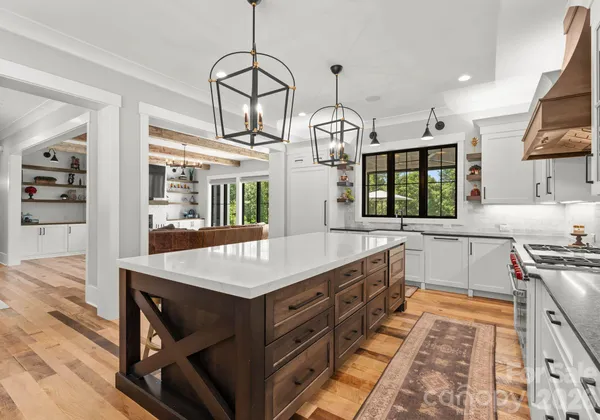 a kitchen with stainless steel appliances granite countertop a stove and a wooden floors