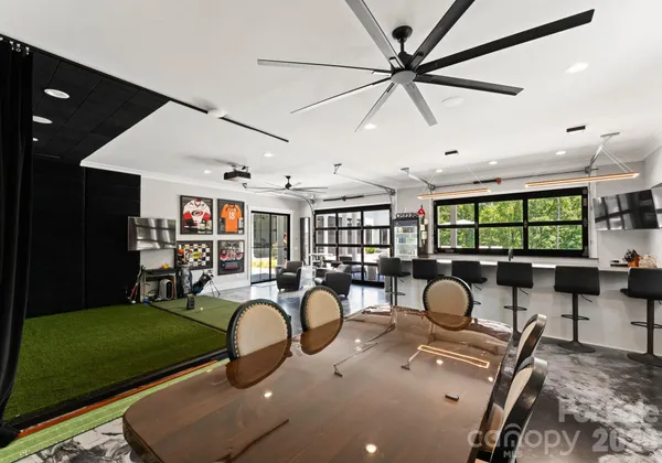 a room with lots of windows ceiling fan and a rug