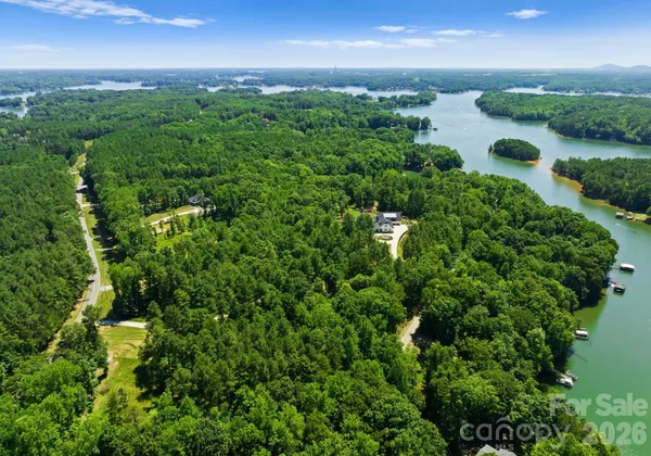 an aerial view of residential houses with outdoor space and trees