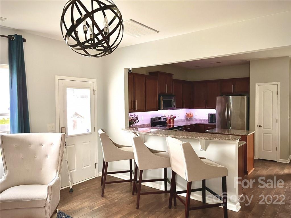 7402 Cedarfield Road Charlotte, NC 28227 - Photo 4 of 15 a living room with a table chairs and a chandelier