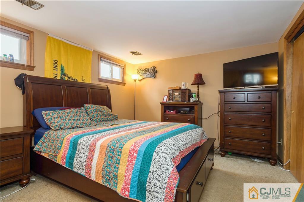 69 Wilk Road Edison, NJ 08837 - Photo 16 of 19 a bedroom with a bed and a flat screen tv