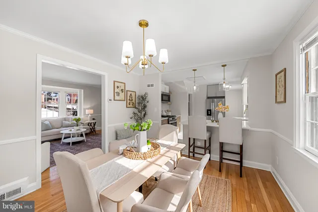 a view of a dining room with furniture a chandelier and wooden floor
