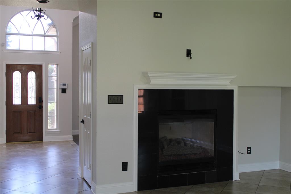 8905 Lakepointe Avenue Rowlett, TX 75088 - Photo 20 of 27 Entrance foyer with light tile patterned floors, a high ceiling, and a tiled fireplace