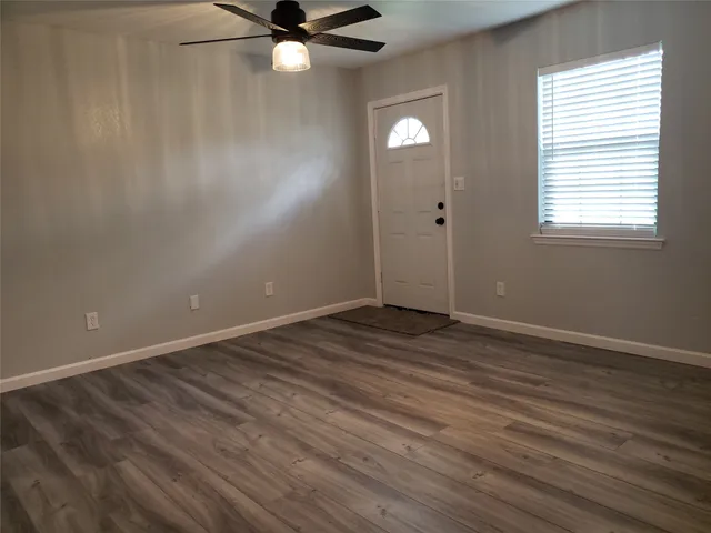 wooden floor in an empty room with a window