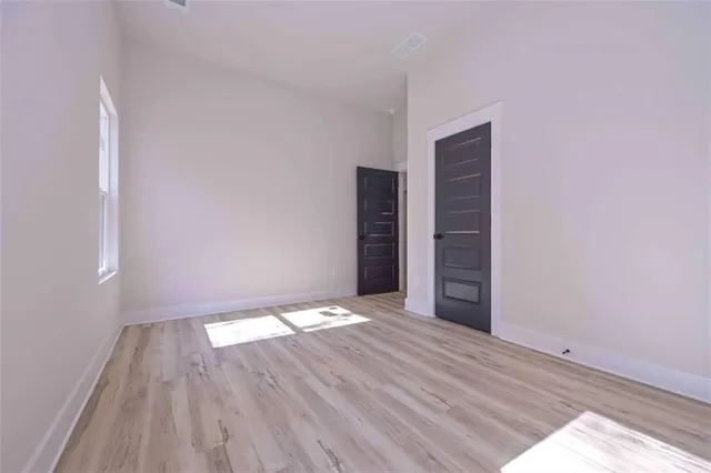 a view of an empty room with a fireplace and wooden floor