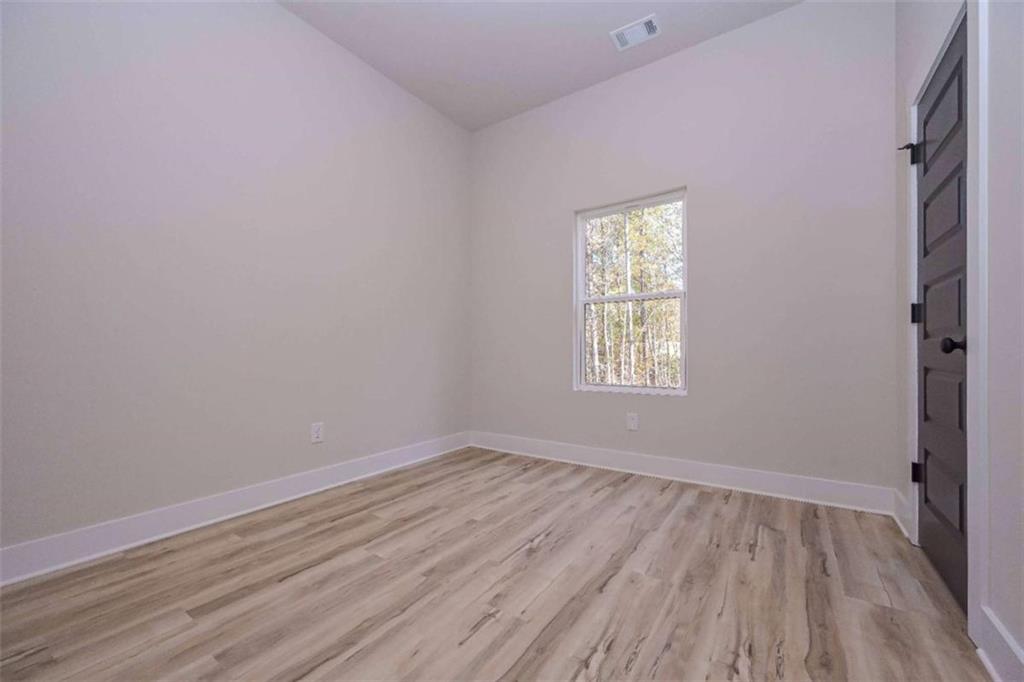 80 Rosemary Way Buchanan, GA 30113 - Photo 18 of 20 a view of an empty room with wooden floor and a window