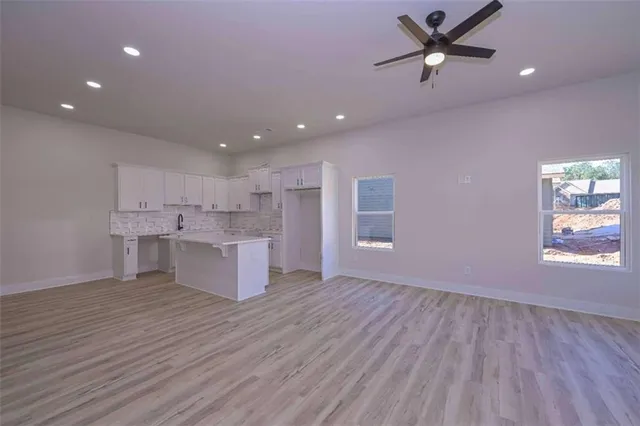 a large kitchen with stainless steel appliances granite countertop a large center island attached withe living room