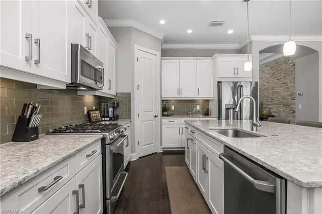 a kitchen with stainless steel appliances granite countertop a sink stove oven and refrigerator