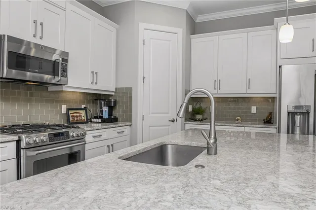 a kitchen with granite countertop a sink a stove and cabinets