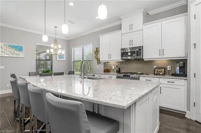 a large kitchen with kitchen island granite countertop a sink a center island and stainless steel appliances