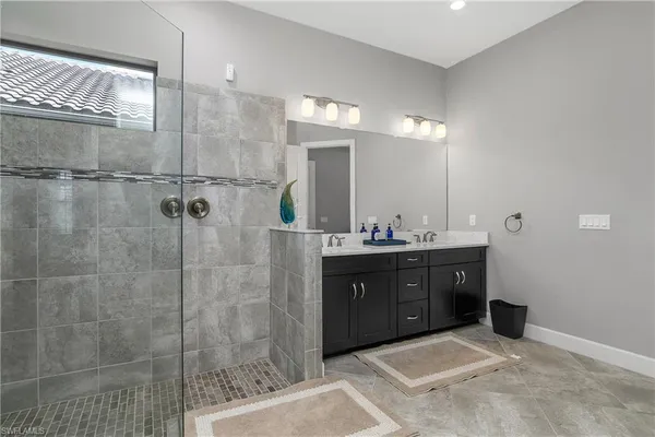 a bathroom with a sink mirror and shower